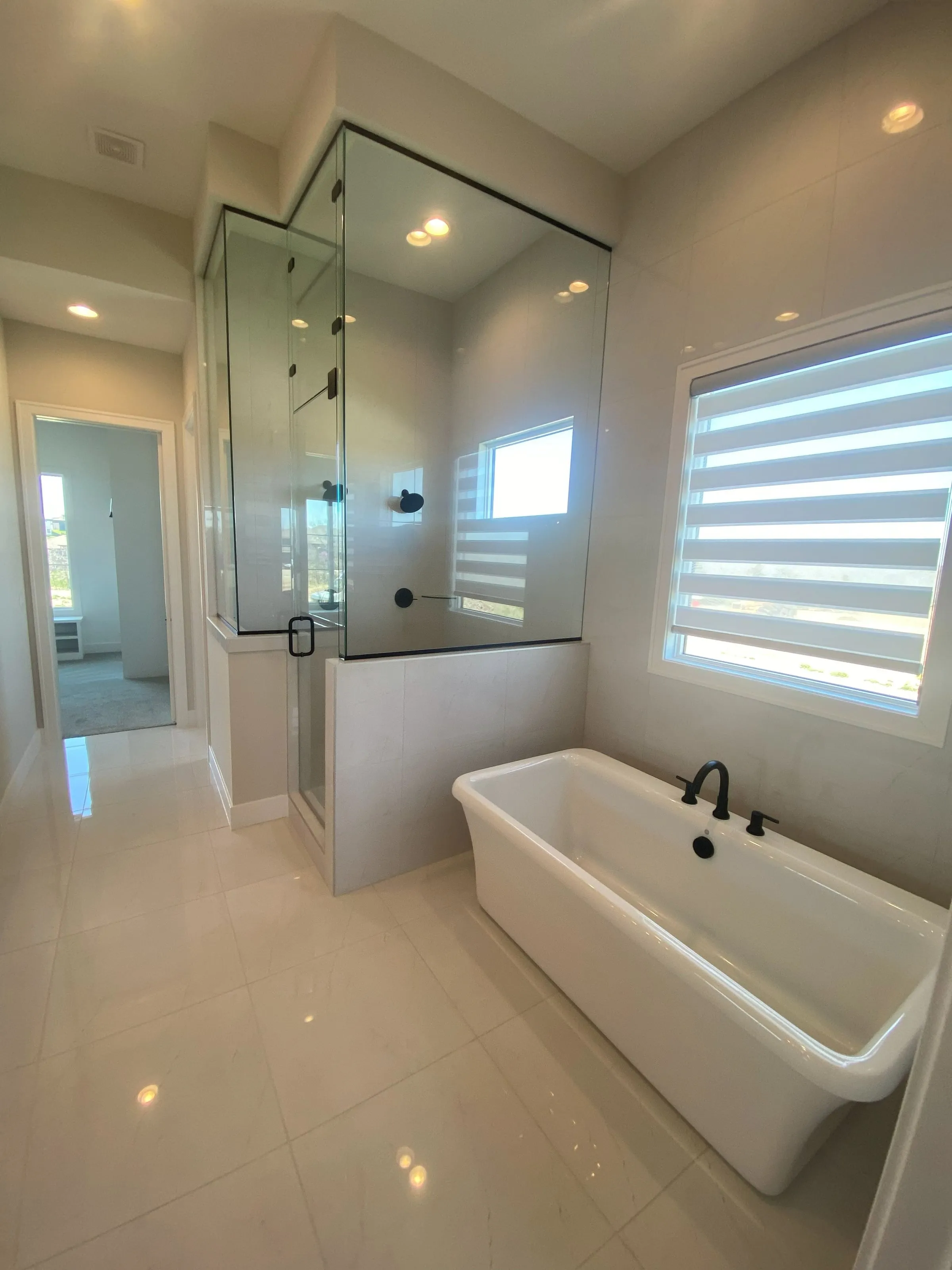 Freestanding soaking tub beside a glass shower in a remodeled bathroom