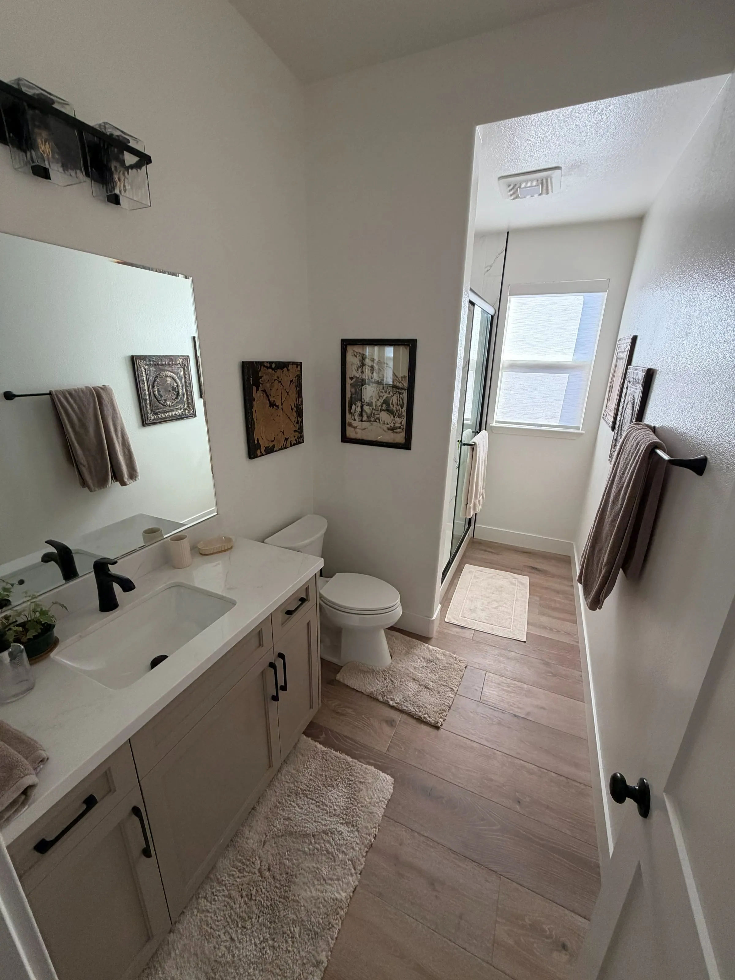 Updated bathroom with a new vanity, black fixtures and wood-look flooring