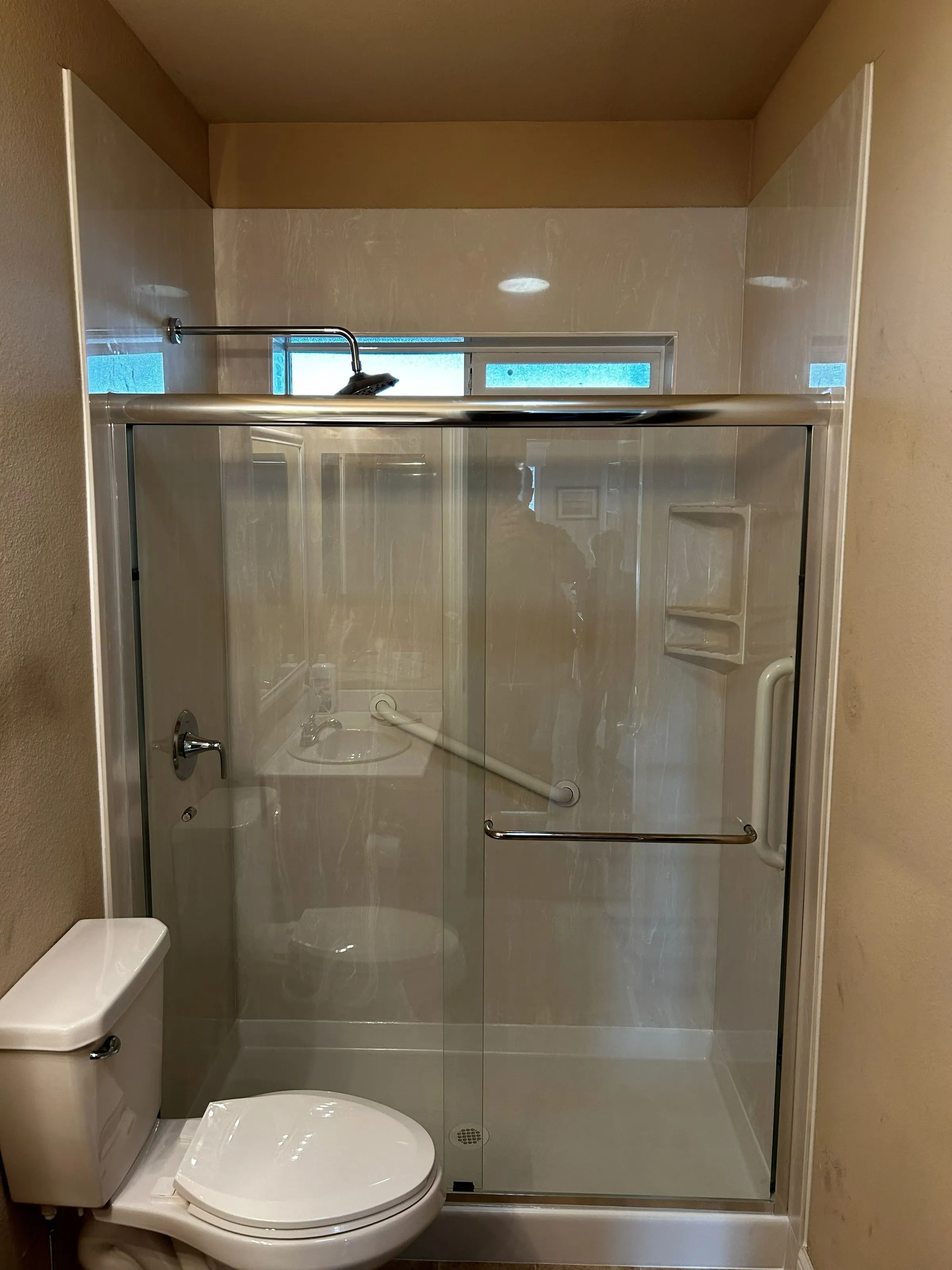 New shower with sliding glass doors and a grab bar for safer, easier use
