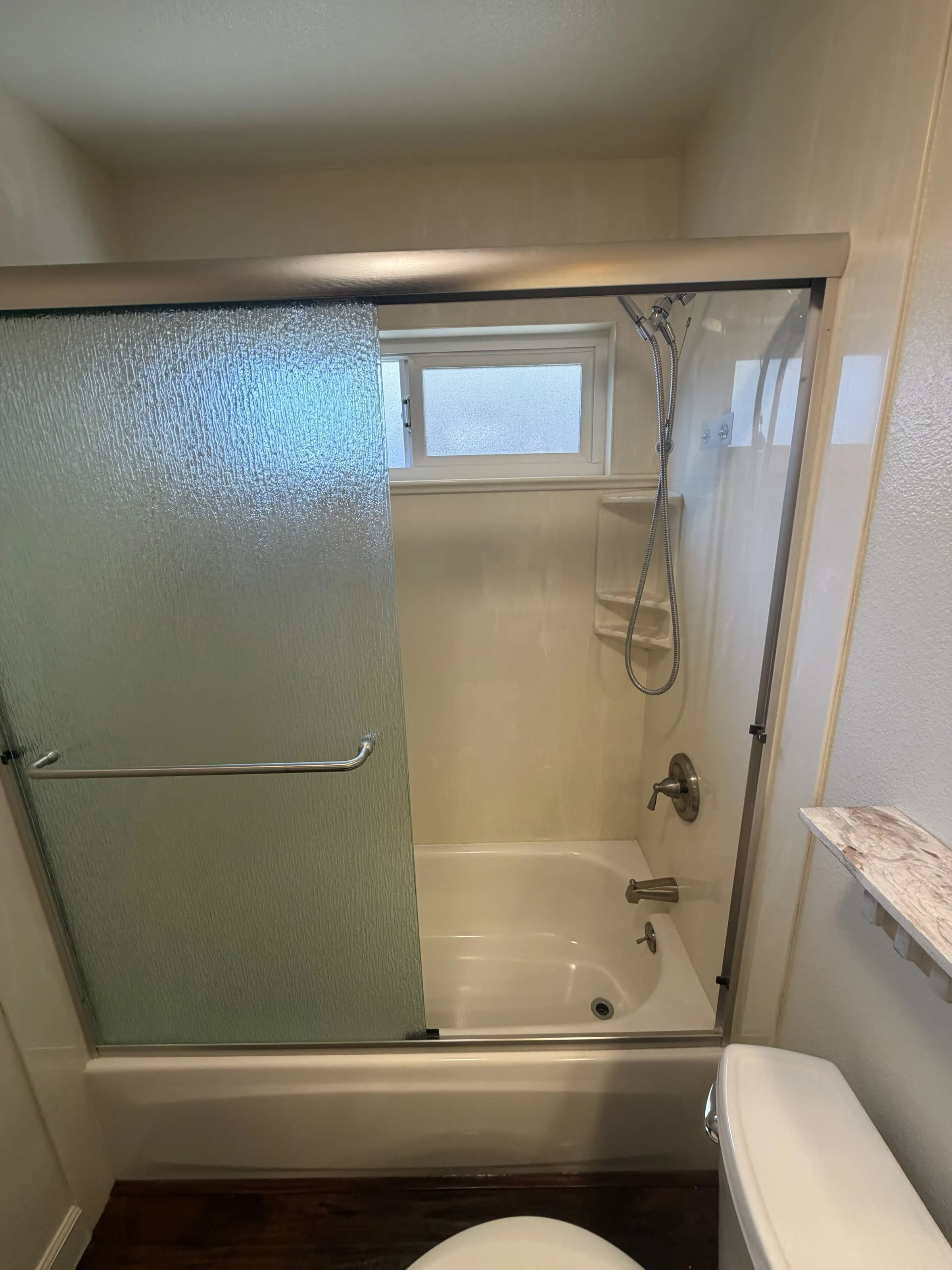 Tub-shower with frosted glass sliding doors and a new surround