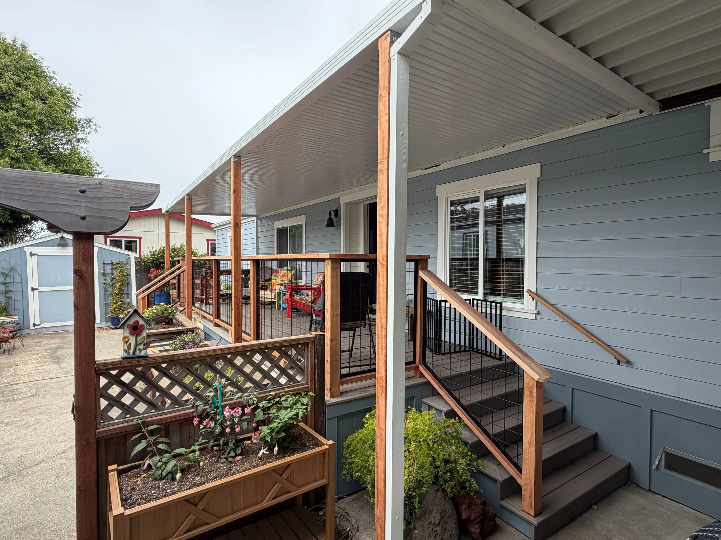 Mobile home side entry with a custom patio cover, composite stairs and redwood handrails