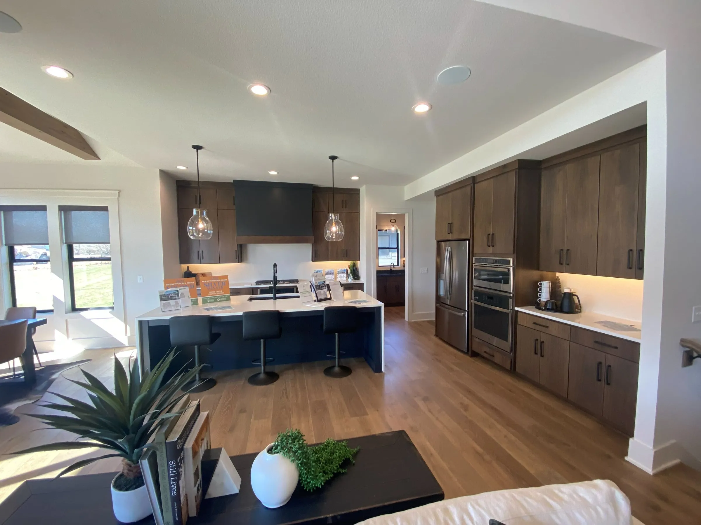 Kitchen with dark wood cabinets, a quartz island with seating and pendant lights