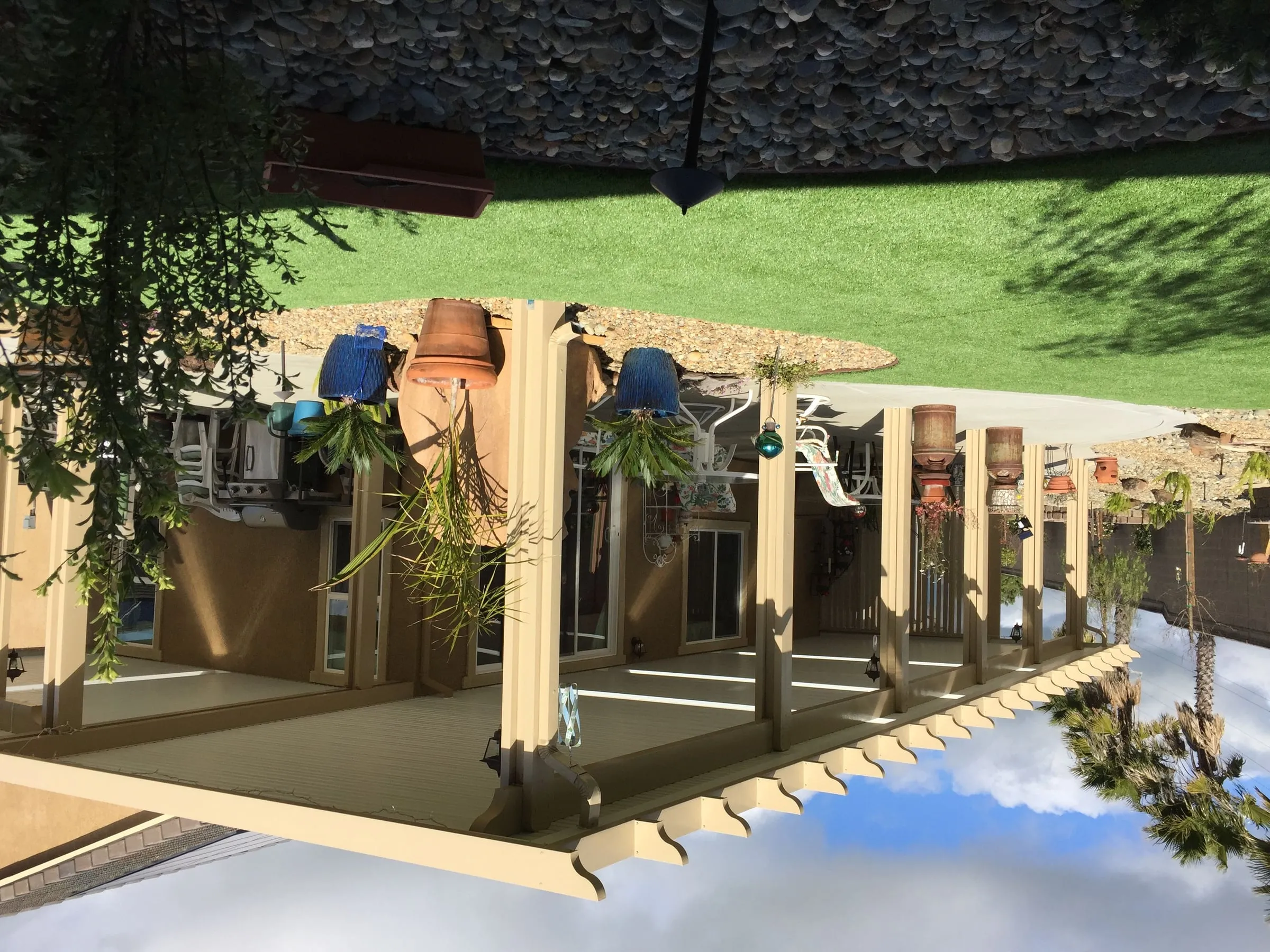 Long tan patio cover with lattice ends across the back of a house