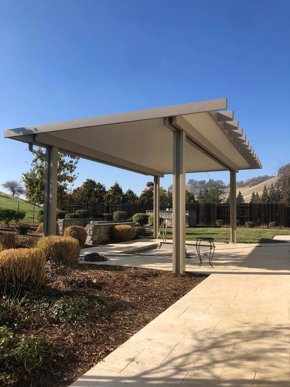 White lattice patio cover over a backyard seating area