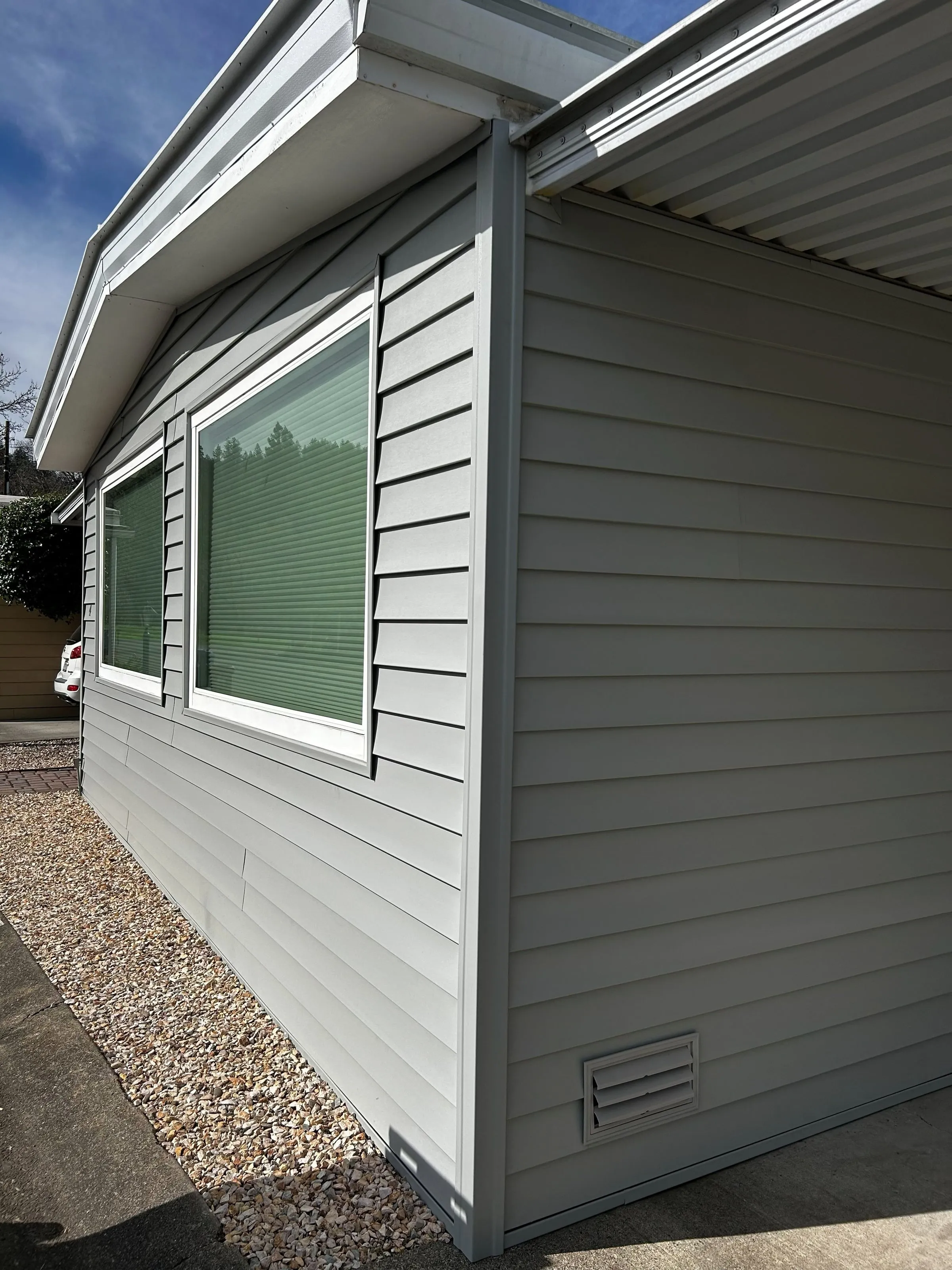 New gray lap siding and trim on the side of a mobile home