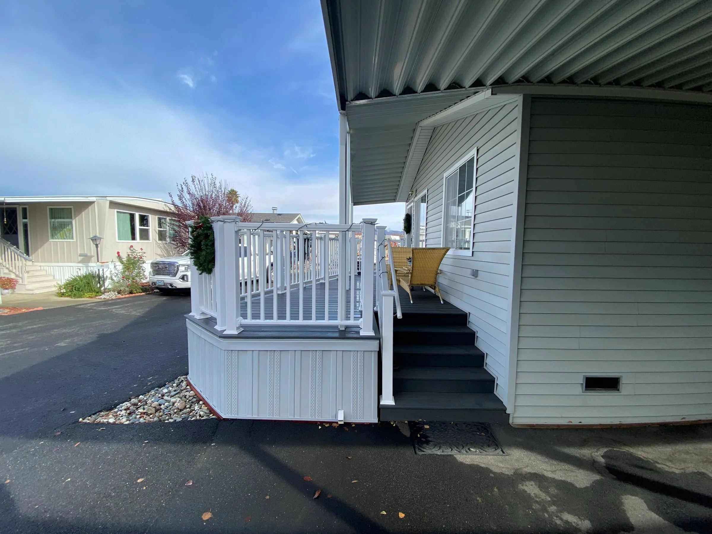 Mobile home porch deck with white railings and wide steps