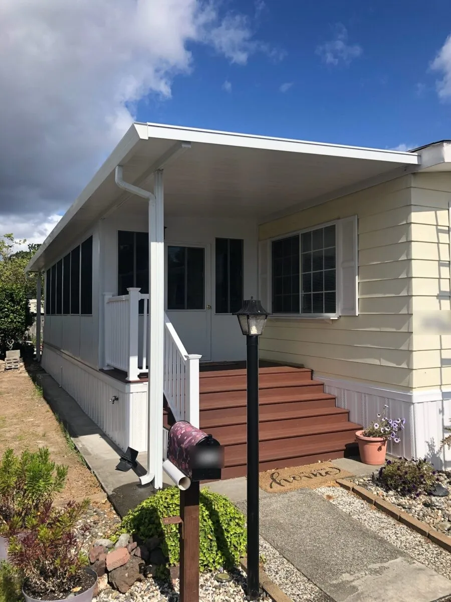 Mobile home porch steps with red treads and handrails