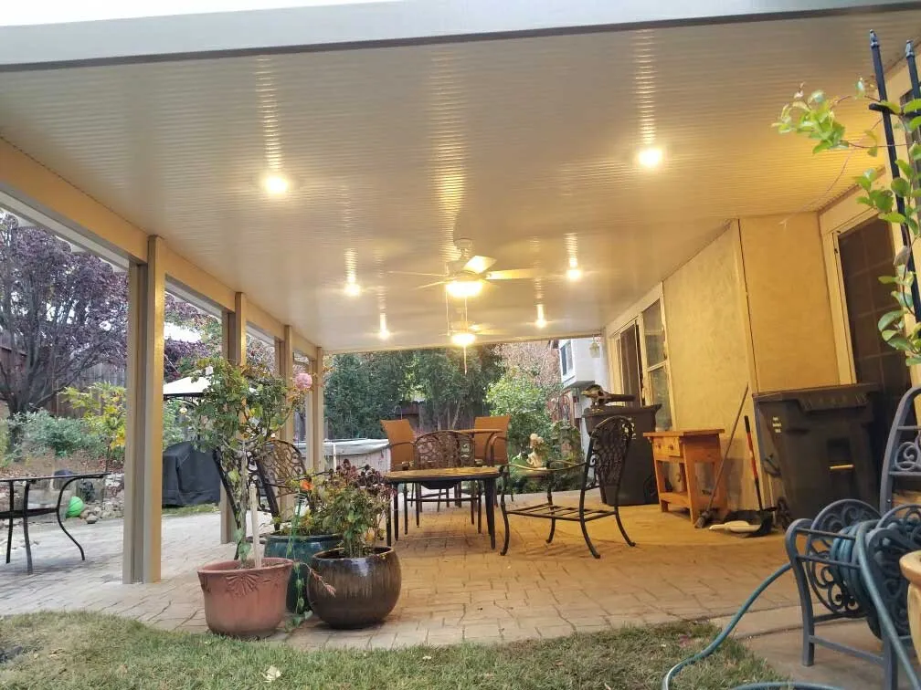 Patio cover lit at dusk with ceiling fans
