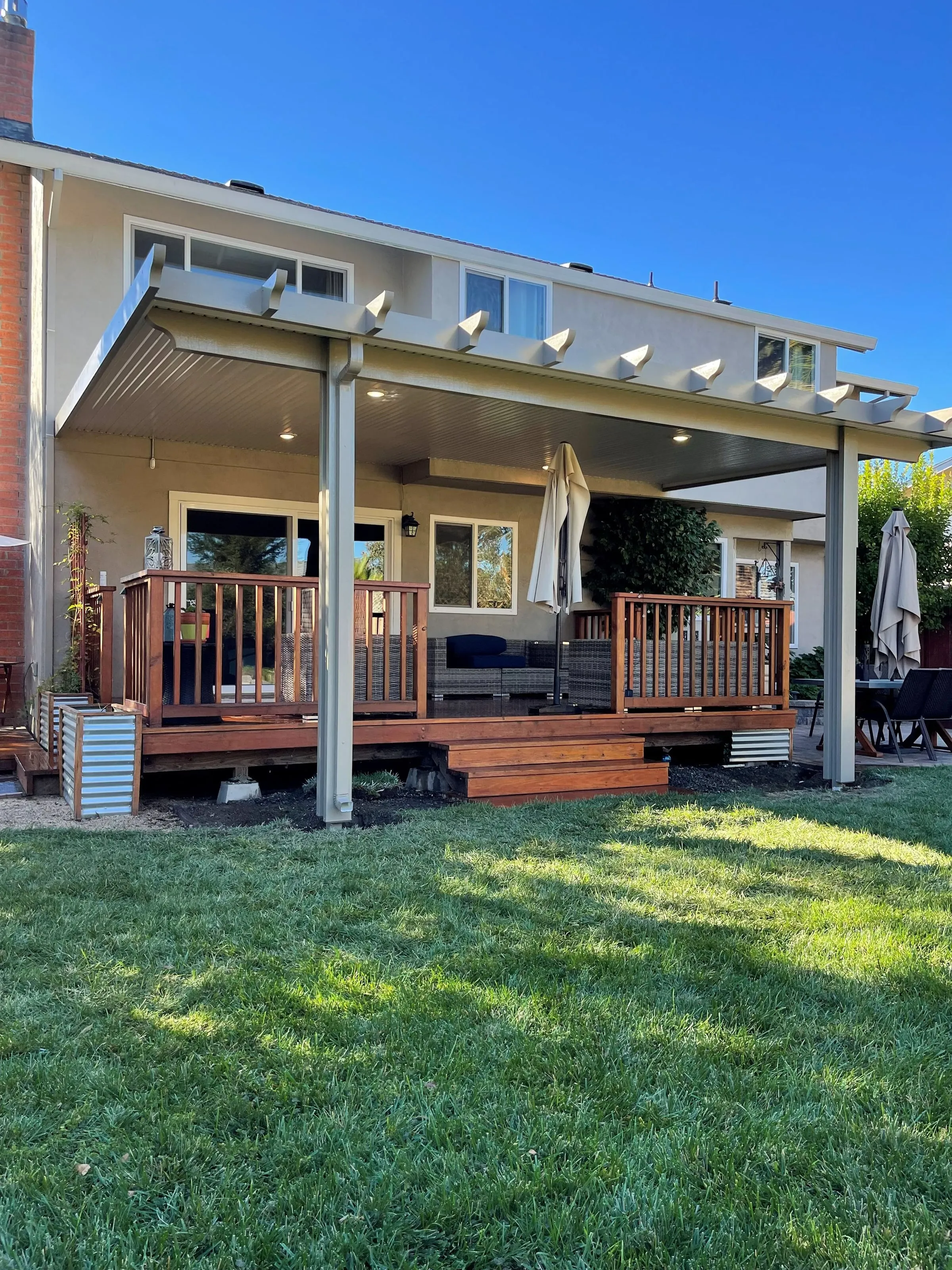White lattice-edged patio cover over a raised redwood deck