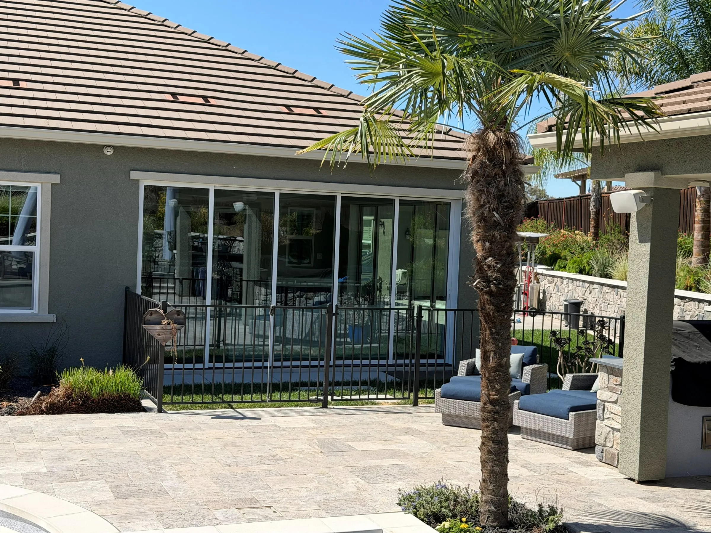 Stucco addition with a wall of sliding glass doors opening onto a paver patio