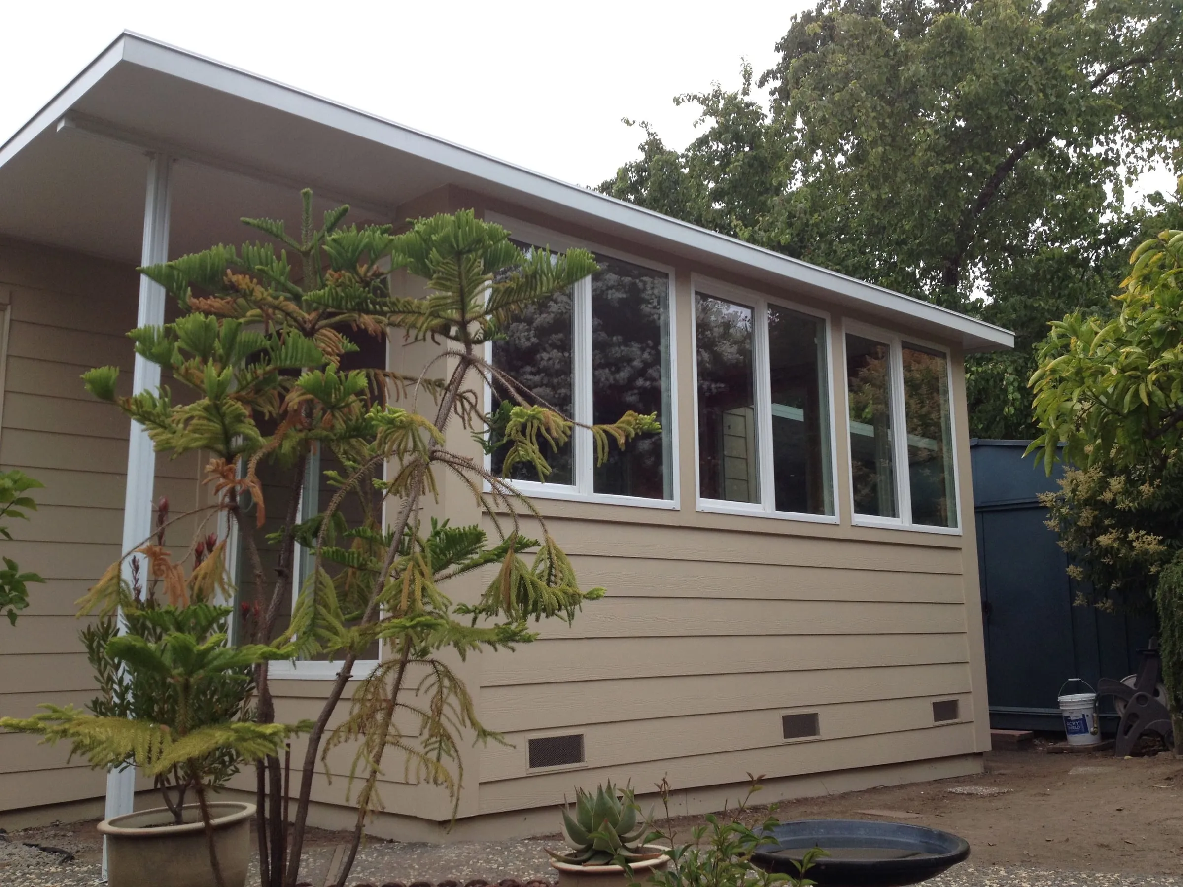 Sunroom addition with a row of tall windows and siding matched to the house