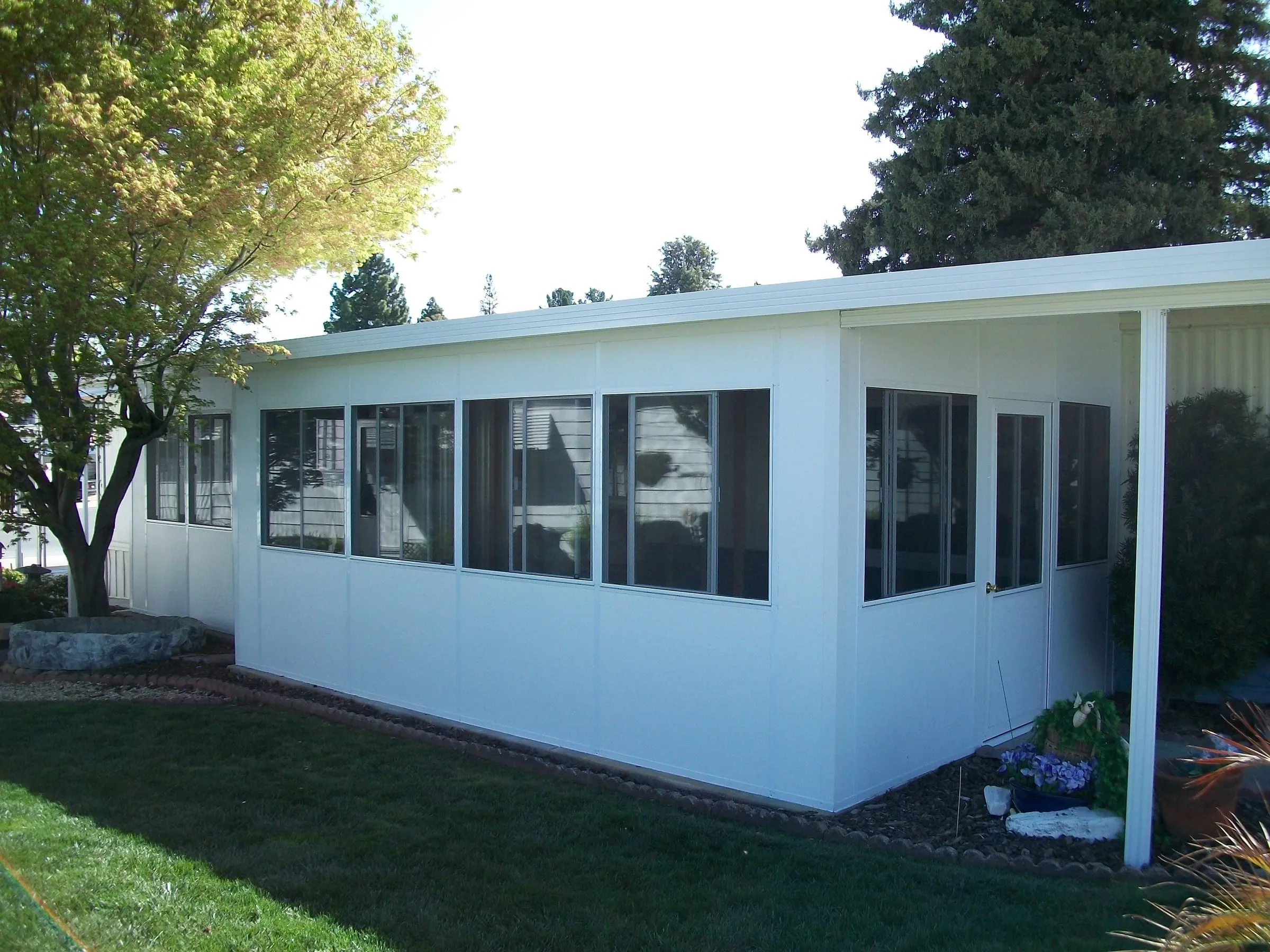 White sunroom enclosure on the back of a home