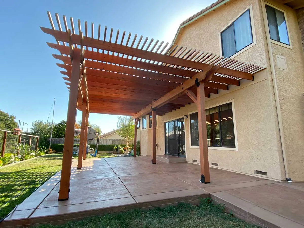 Wood pergola over a colored concrete patio